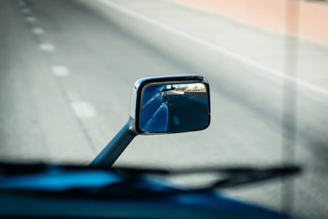 Semi truck rear view side mirror hood mounted